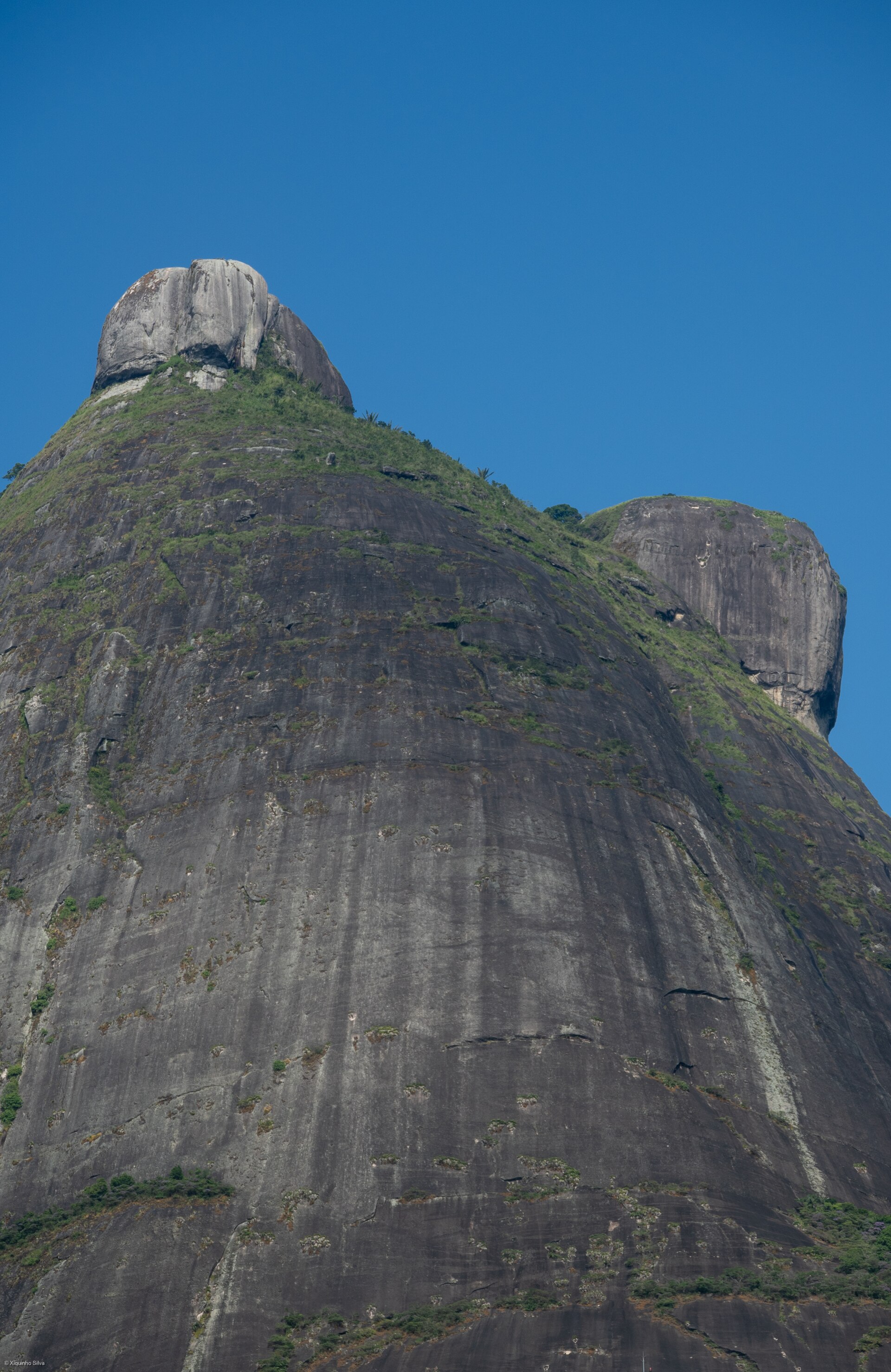 Dois cumes de granito sob céu limpo no Parque Nacional da Tijuca, Rio de Janeiro.